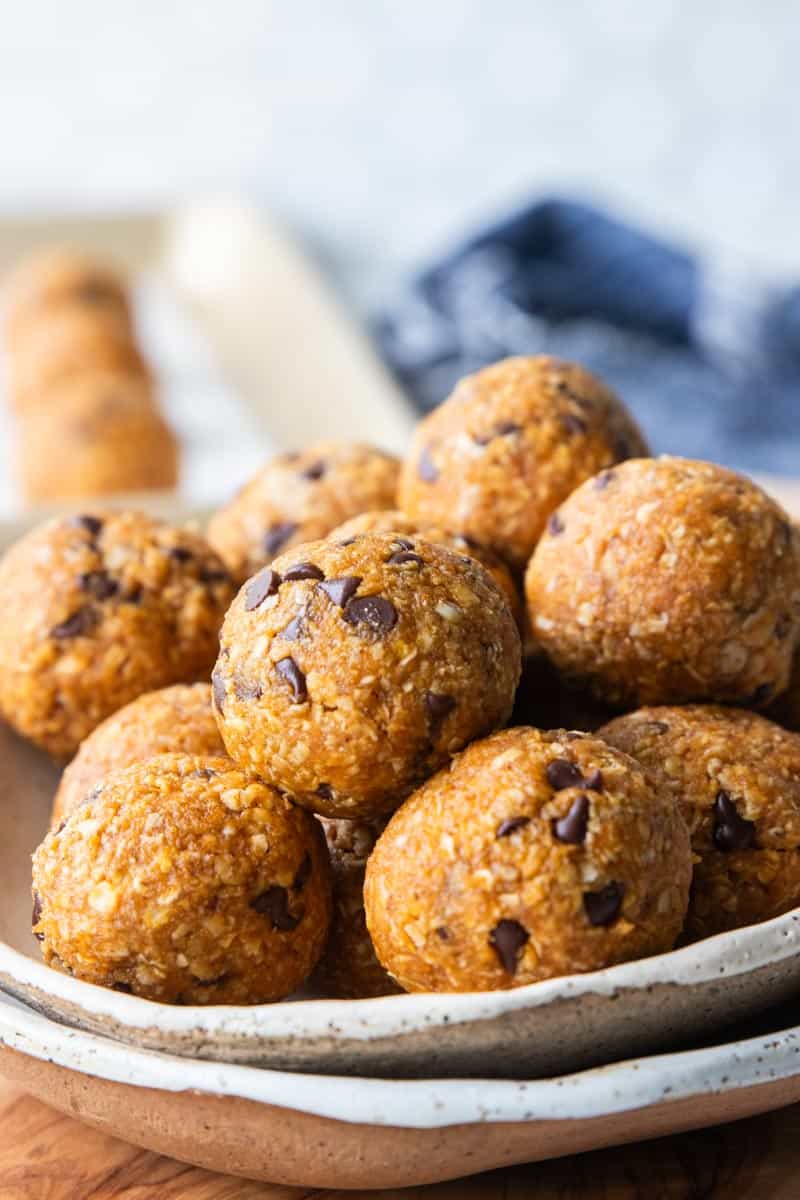 a closes up of pumpkin protein balls stacked in a bowl