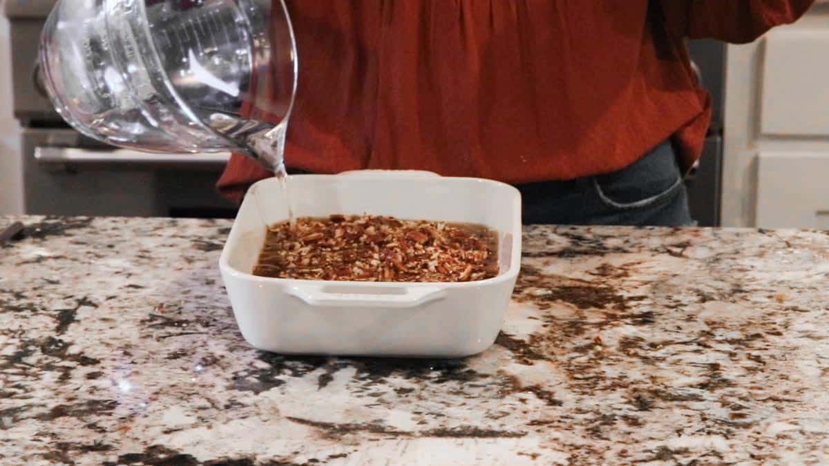 hot water being added on top of pecan pie cobbler before baking
