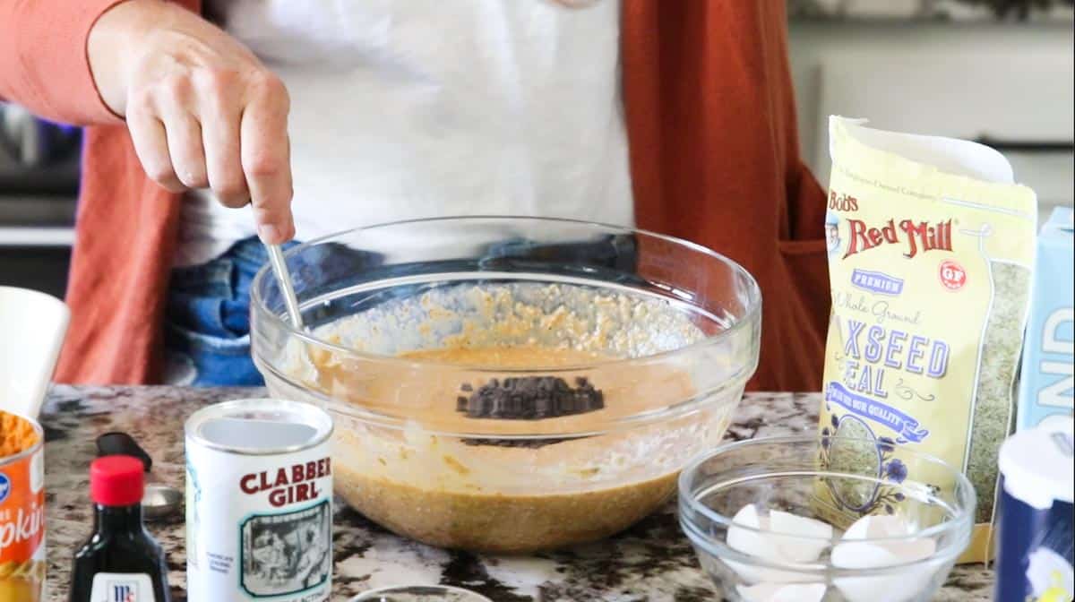 chocolate chips added to a mixture in a bowl
