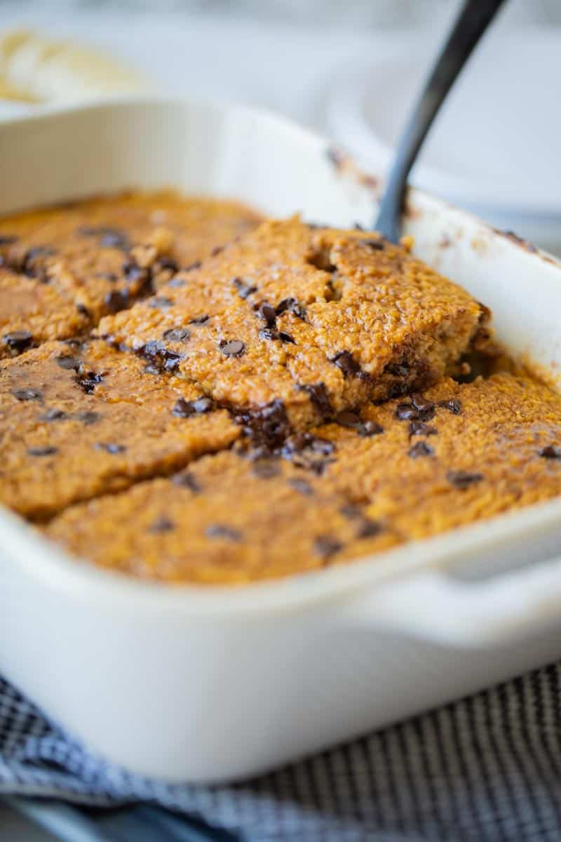 pumpkin baked oatmeal in a pan with a slice being removed