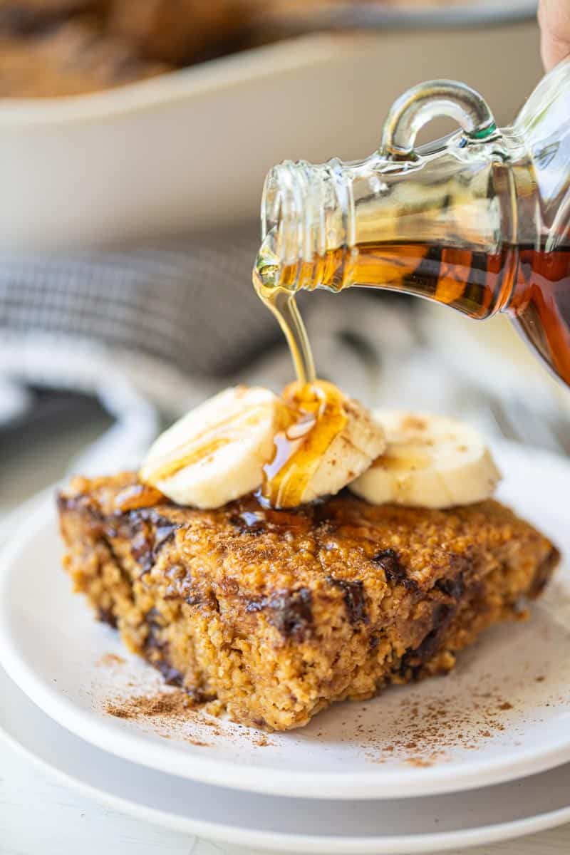 pumpkin baked oatmeal slice with maple syrup being drizzled on top