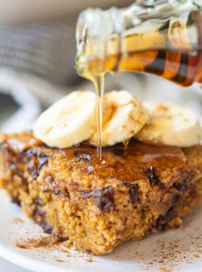 pumpkin baked oatmeal slice with maple syrup being drizzled on top