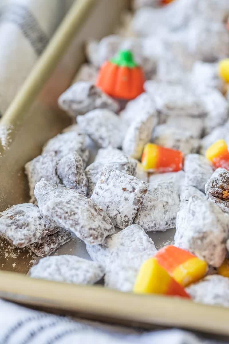halloween muddy buddies on a baking sheet with candy corn and mallowcreme pumpkins
