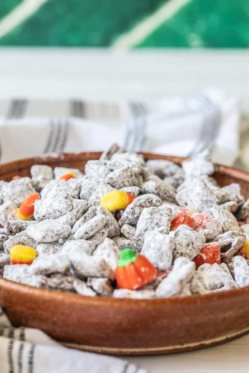 halloween muddy buddies in a bowl with candy corn and mallowcreme pumpkins