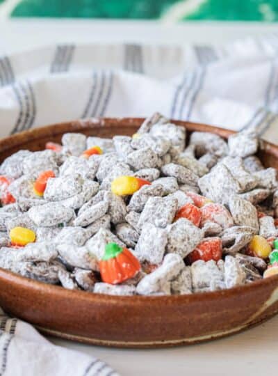 halloween muddy buddies in a bowl with candy corn and mallowcreme pumpkins