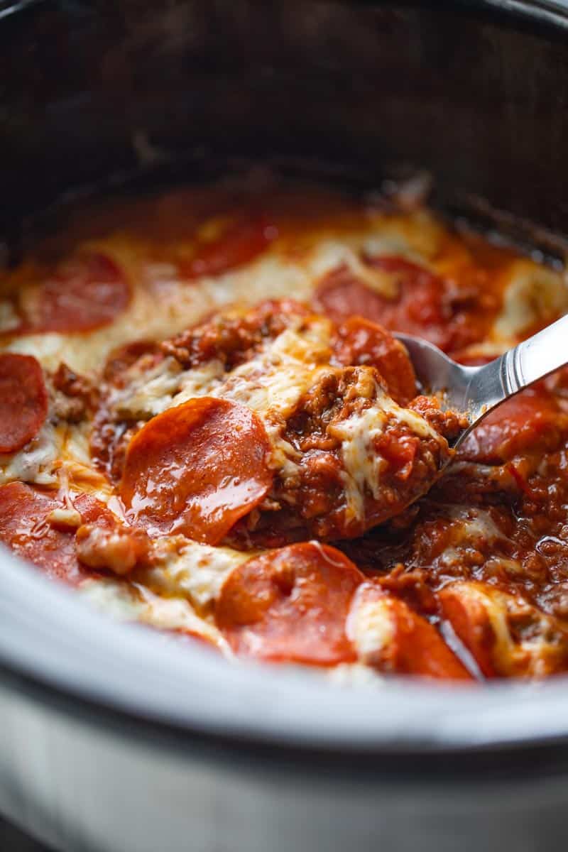 spoon scooping crockpot pizza casserole