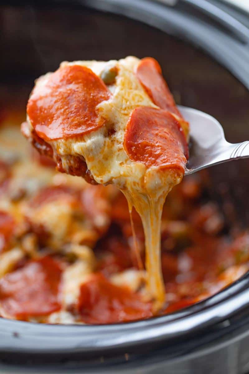 cheesy pizza casserole scooped from slow cooker