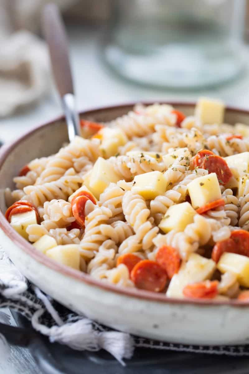 pizza pasta salad in a serving bowl with a spoon