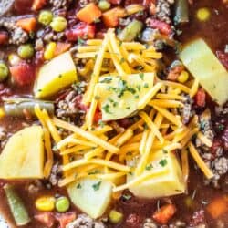top down view of hamburger soup topped with shredded cheese