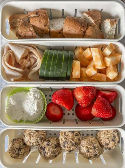 a shot of a 4 compartment snack box with food in ti